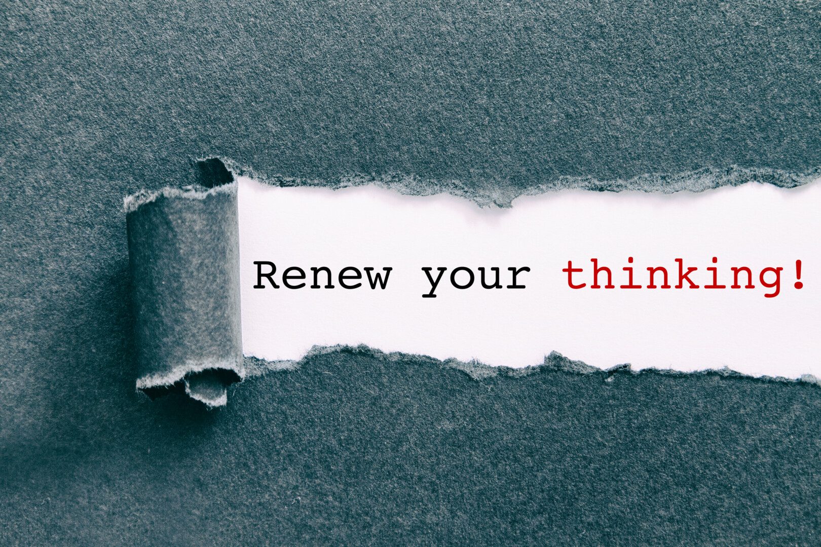 Torn paper with the words renew your thinking.